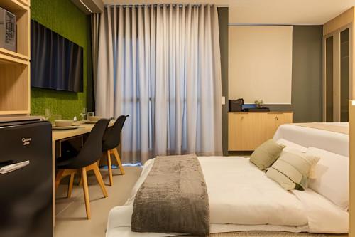 a bedroom with a large bed and a desk and a table at Today Perdizes in Sao Paulo