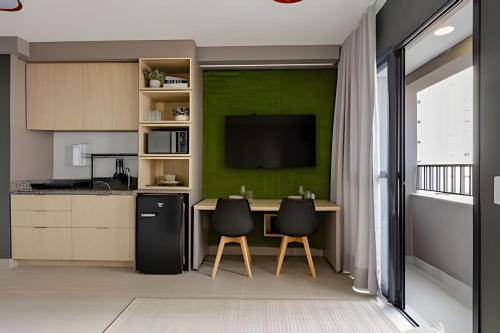 a kitchen with a table with two chairs and a television at Today Perdizes in Sao Paulo