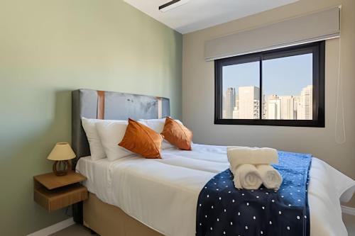 a bedroom with a large bed with a window at Today Perdizes in Sao Paulo