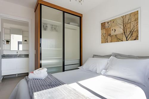 a bedroom with a large white bed and a mirror at Today Perdizes in Sao Paulo