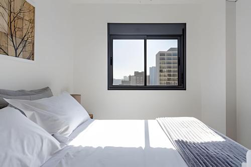 a bedroom with a white bed and a window at Today Perdizes in Sao Paulo