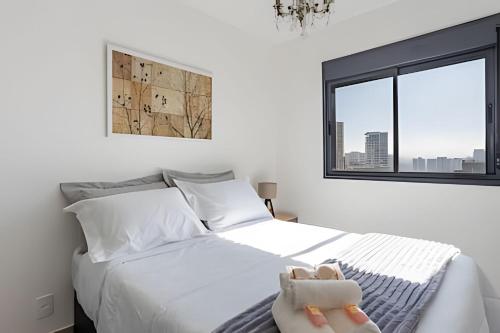 a bedroom with a bed with white sheets and a window at Today Perdizes in Sao Paulo