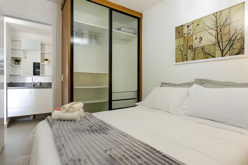 a bedroom with a white bed and a bathroom at Today Perdizes in Sao Paulo