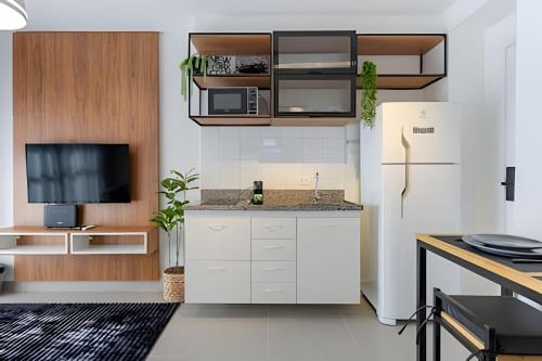 a kitchen with white cabinets and a refrigerator at Today Perdizes in Sao Paulo
