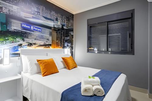 a bedroom with a large white bed with orange pillows at Today Perdizes in Sao Paulo