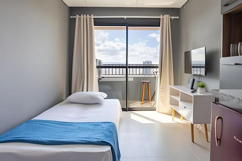 a bedroom with a bed and a large window at Today Perdizes in Sao Paulo