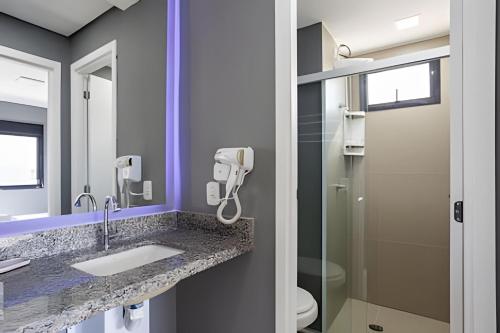 a bathroom with a sink and a shower at Today Perdizes in Sao Paulo