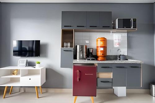 a kitchen with gray cabinets and a purple refrigerator at Today Perdizes in Sao Paulo