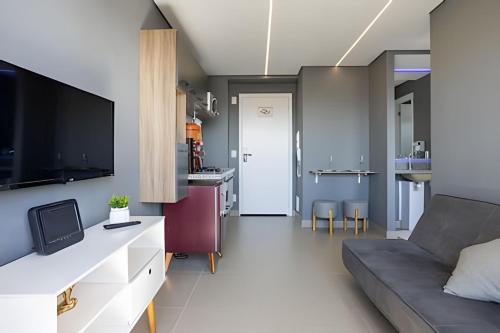 a living room with a couch and a tv at Today Perdizes in Sao Paulo