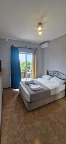a bedroom with a large bed and a large window at PharphalInn in Batumi