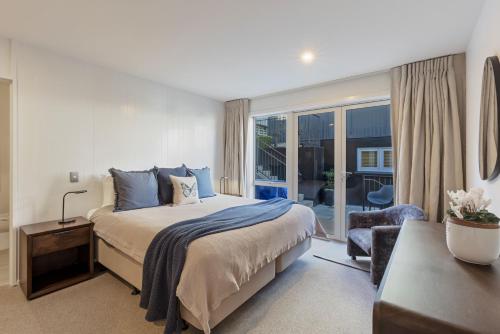 a bedroom with a bed and a large window at Queenstown House Bed & Breakfast and Apartments in Queenstown