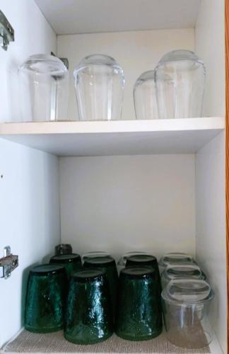 a closet with green glass jars on shelves at TriΖin in Galatas