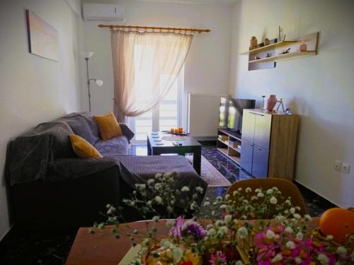 a living room with a couch and a table with flowers at TriΖin in Galatas