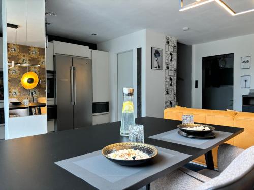 a kitchen and living room with a table with two bowls of food at Ruhe Oase Steinhöfel - Balkon, Naturblick, Design-Maisonette-Apartment - nahe Fürstenwalde-Spree in Steinhöfel