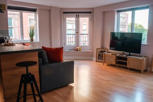a living room with a couch and a flat screen tv at Central Manchester Gem with Stylish 2BR Retreat and Free Carpark in Manchester