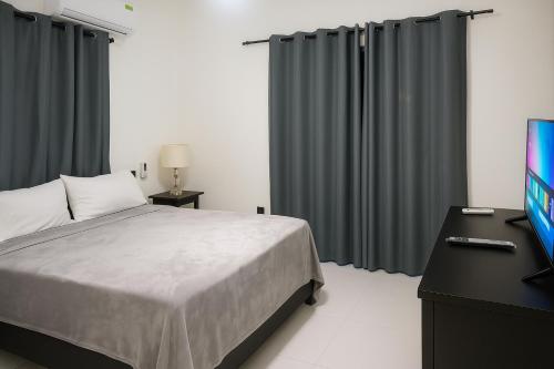 a bedroom with a bed and a flat screen tv at Modern 3 Bedroom Penthouse Apartment with Free Parking in San Felipe de Puerto Plata
