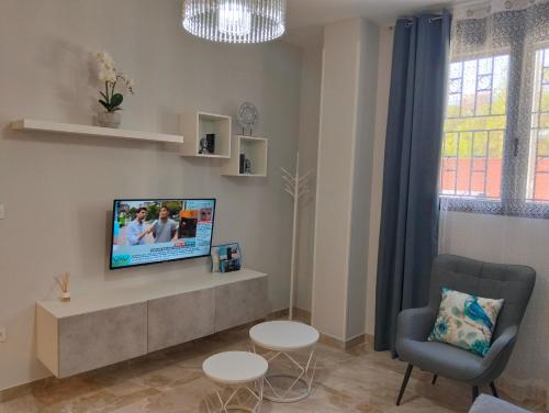 a living room with a tv and a chair at APARTAMENTO SOL - 2 apartamentos céntricos juntos cerca de la playa, ideales para grupos grandes in Águilas