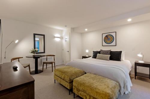 a bedroom with a bed and a table and a chair at Queenstown House Bed & Breakfast and Apartments in Queenstown