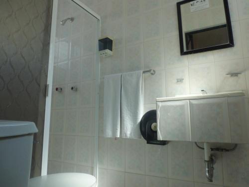 a bathroom with a shower with a toilet and a mirror at Suites Angelopolis in Acapulco