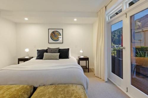 a bedroom with a large bed and a large window at Queenstown House Bed & Breakfast and Apartments in Queenstown