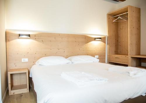 a bedroom with a large white bed with two pillows at AL Borgo in Tempio