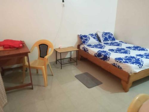 a bedroom with a bed and a table and a desk at Fèmi in Rufisque