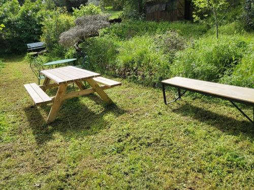 a picnic table and a bench in the grass at Appart 8 personnes Jardin Parkings Voitures Vélos,10min Château,40min Zoo Beauval in Blois