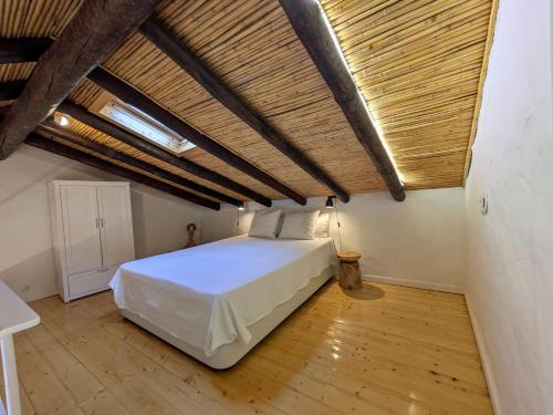 une chambre avec un grand lit dans un grenier dans l'établissement Laranjeira 2 by AlmaAlgarvia, à Santa Bárbara de Nexe