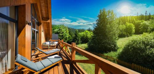 Una terraza con tumbonas y vista al bosque. en Chalet Oasis - Luxury 5-Bedroom Chalet with Panoramic Views, en Huty