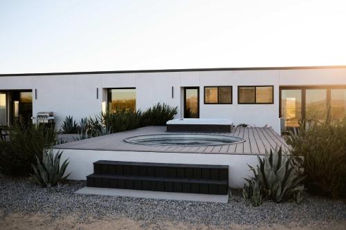 Una casa con una fogata en el frente. en SkyDweller - Joshua Tree Modern, en Joshua Tree