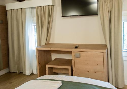 a bedroom with a bed and a wooden desk at AL Borgo in Tempio