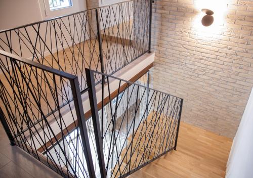 a staircase with metal railing and a brick wall at AL Borgo in Tempio