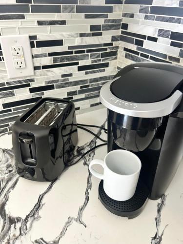 a coffee maker and a cup on a counter at Grey Novo Studio + free-parking&wifi in Tampa