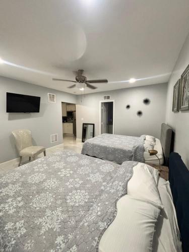 a bedroom with two beds and a flat screen tv at Grey Novo Studio + free-parking&wifi in Tampa