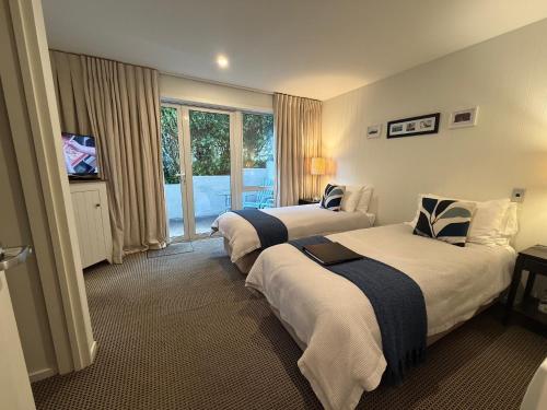 a hotel room with two beds and a television at Queenstown House Bed & Breakfast and Apartments in Queenstown