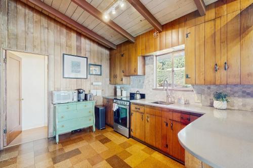 a kitchen with wooden cabinets and a sink and a stove at Mintercreek Cabin in Gig Harbor