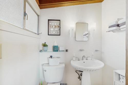 a white bathroom with a toilet and a sink at Mintercreek Cabin in Gig Harbor