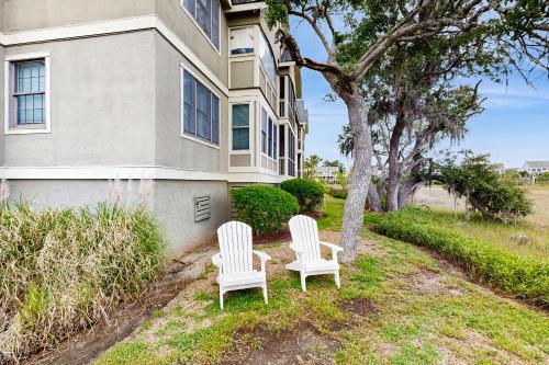 two white chairs sitting in front of a house at Bay Pointe 2119 in Seabrook Island
