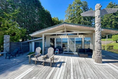 a wooden deck with two chairs and a cross at Mintercreek Cabin in Gig Harbor