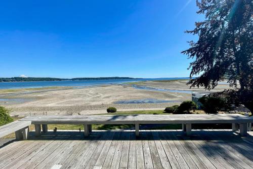 a bench sitting on a deck looking out at the water at Mintercreek Cabin in Gig Harbor
