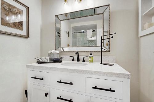 Un baño blanco con lavabo y espejo. en Bay Pointe 2119, en Seabrook Island