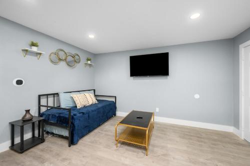 a living room with a bed and a tv at Hip & Quirky Montrose Flat with Pool Access & Parking in Houston