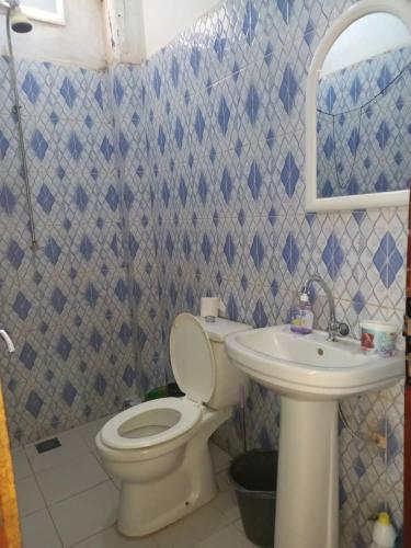 a bathroom with a toilet and a sink at Fèmi in Rufisque
