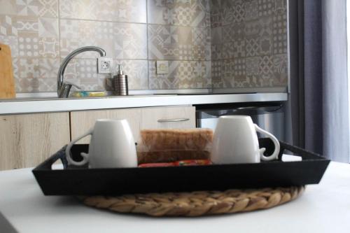 a tray with two mugs on top of a kitchen counter at stuDio 57 II in Alexandroupoli
