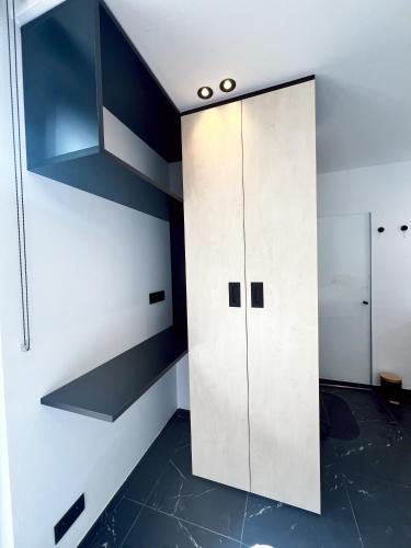 a white cabinet in a room with black floors at Serenity Lodge Durbuy - Sauna & Jacuzzi in Durbuy