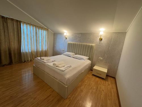 a bedroom with a bed with two towels on it at Karo Hotel in K'obulet'i