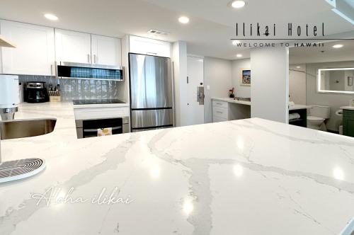 a kitchen with white cabinets and a white counter top at New Aloha Waikiki Ilikai Hotel Condo Free Parking in Honolulu