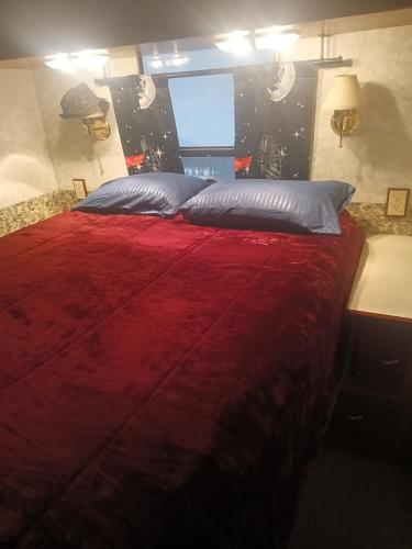 a bedroom with a large bed with a red blanket at Motorhome Casa rodante in San Mateo Río Hondo