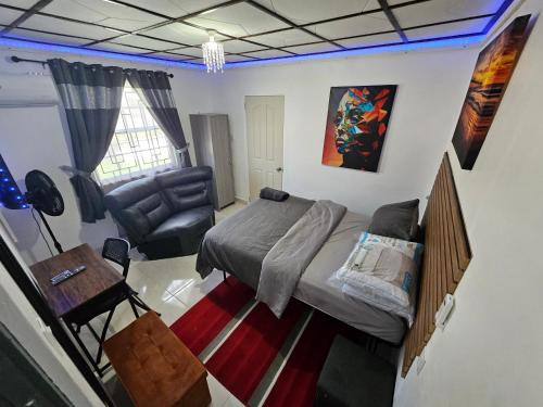 a bedroom with a bed and a desk and a chair at Sunrise Haven Holiday Apartments Barbados in Christ Church
