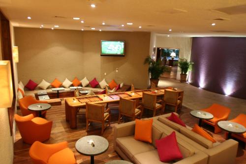 a hotel lobby with couches and tables and a television at Las Brisas Ixtapa in Ixtapa